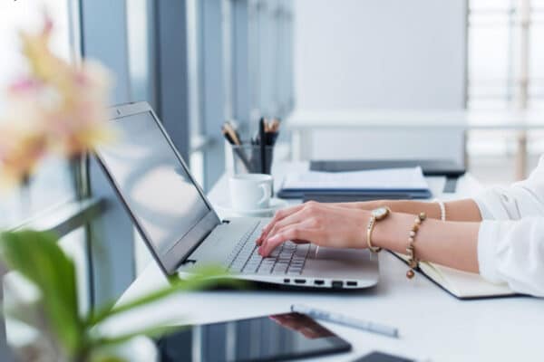 Female copywriter at her workplace, home, writing new text using laptop and Wi-Fi internet connection in the morning